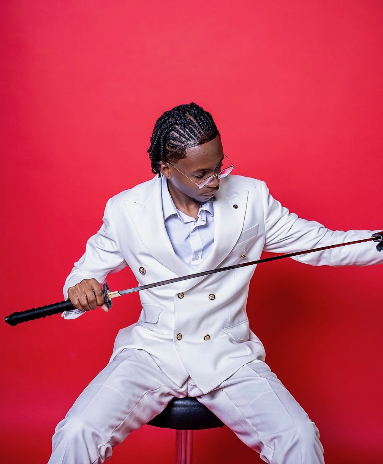 Self-portrait — the hand behind Lost in Black Custom Co., in a white suit against deep red.